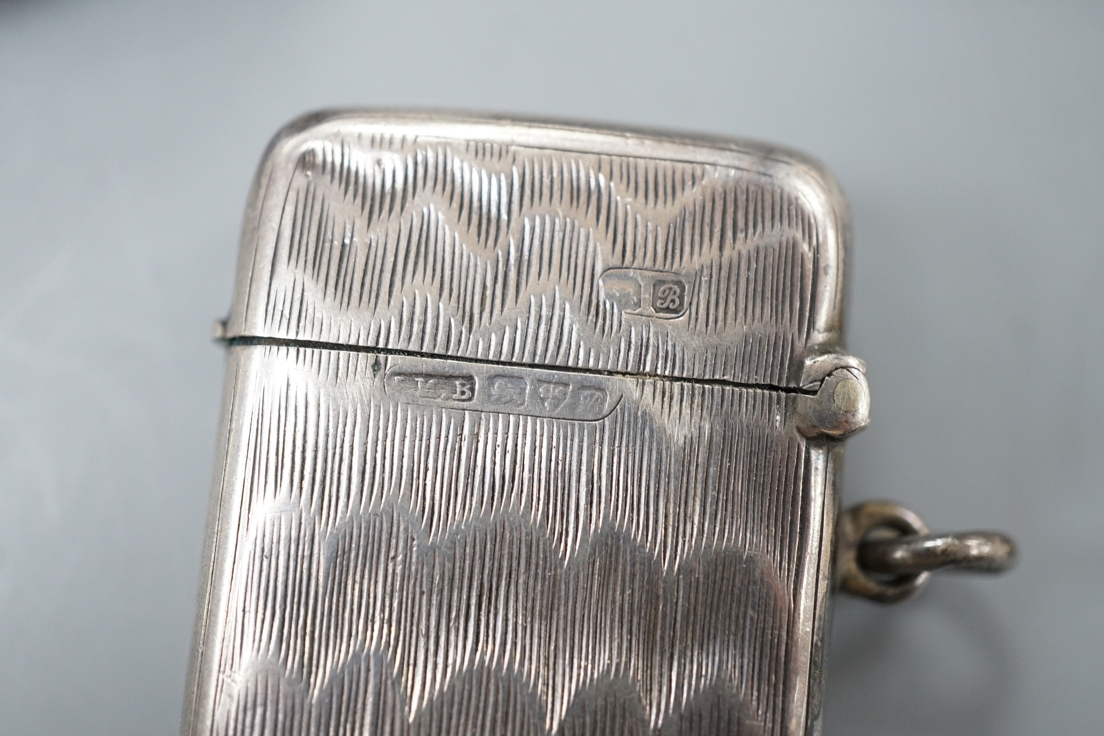Four assorted early 20th century silver vesta cases, including a silver gilt mounted nut, and patent action circular, together with a sterling vesta case and ornate handled sauce ladle and a mother of pearl handed silver